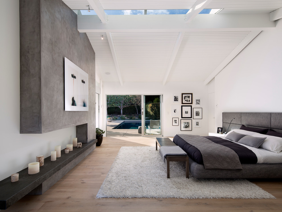 Design ideas for a midcentury master bedroom in Santa Barbara with white walls and light hardwood floors.