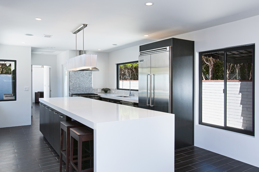 Photo of a large contemporary l-shaped open plan kitchen in Other with an undermount sink, flat-panel cabinets, dark wood cabinets, quartz benchtops, grey splashback, stone tile splashback, stainless steel appliances, porcelain floors and with island.