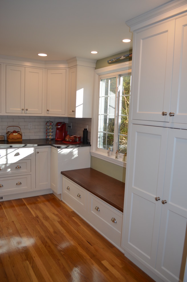 Eat-in kitchen - transitional l-shaped light wood floor eat-in kitchen idea in Boston with an undermount sink, beaded inset cabinets, white cabinets, quartz countertops, white backsplash, ceramic backsplash, stainless steel appliances, an island and gray countertops