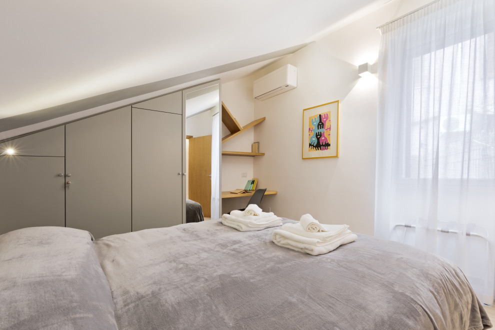 This is an example of a mid-sized contemporary master bedroom in Rome with white walls, porcelain floors, no fireplace and beige floor.