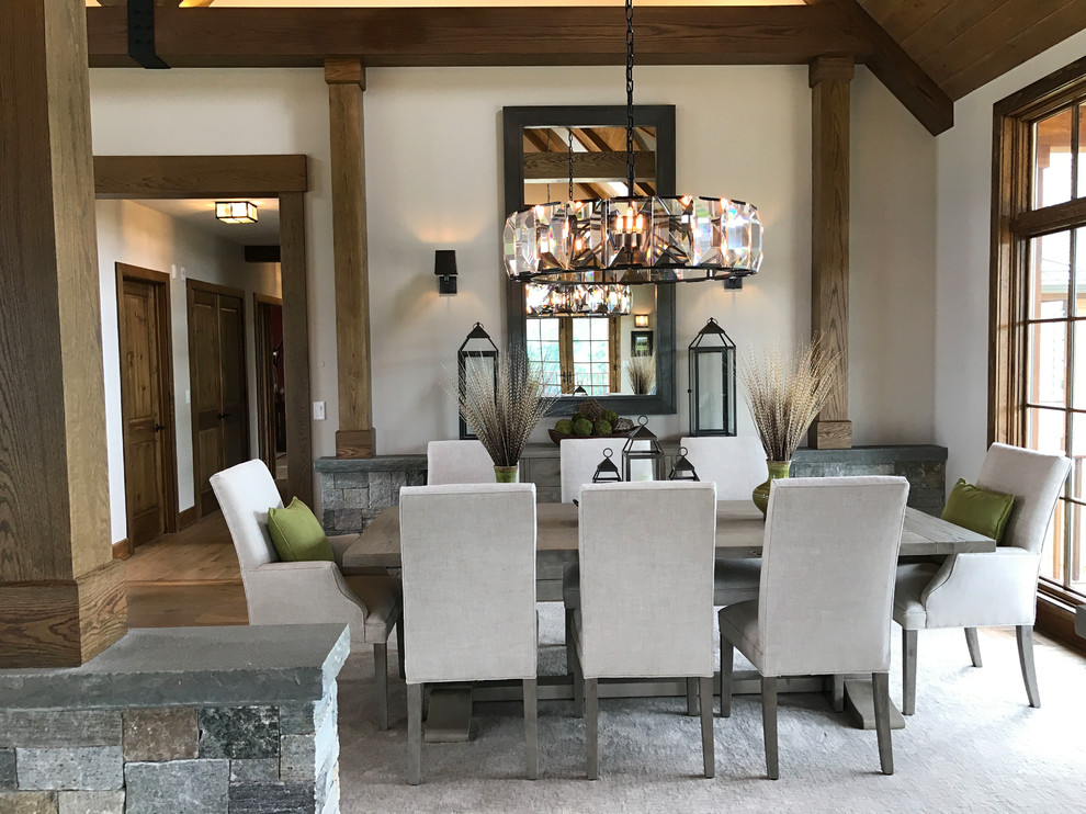 Photo of an expansive country open plan dining in Philadelphia with beige walls, medium hardwood floors, a standard fireplace, a stone fireplace surround and brown floor.