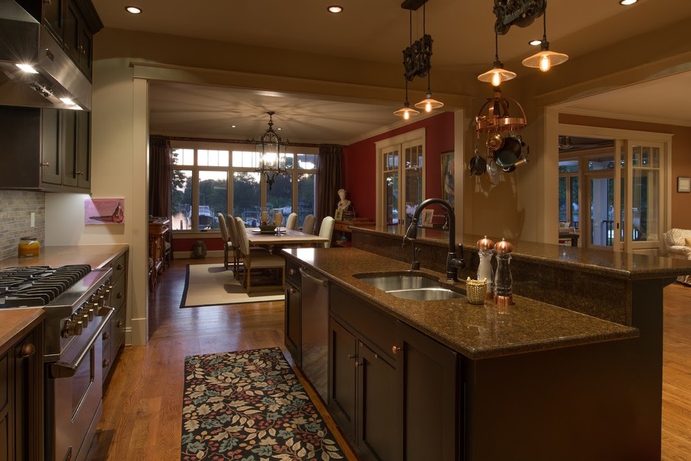 Inspiration for a mid-sized transitional l-shaped medium tone wood floor open concept kitchen remodel in DC Metro with an undermount sink, shaker cabinets, black cabinets, quartz countertops, brown backsplash, ceramic backsplash, stainless steel appliances and an island