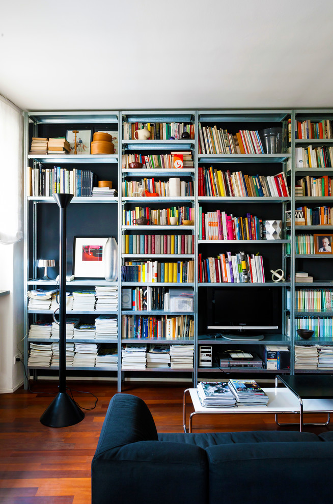 Mid-sized contemporary living room in Milan with a library and white walls.