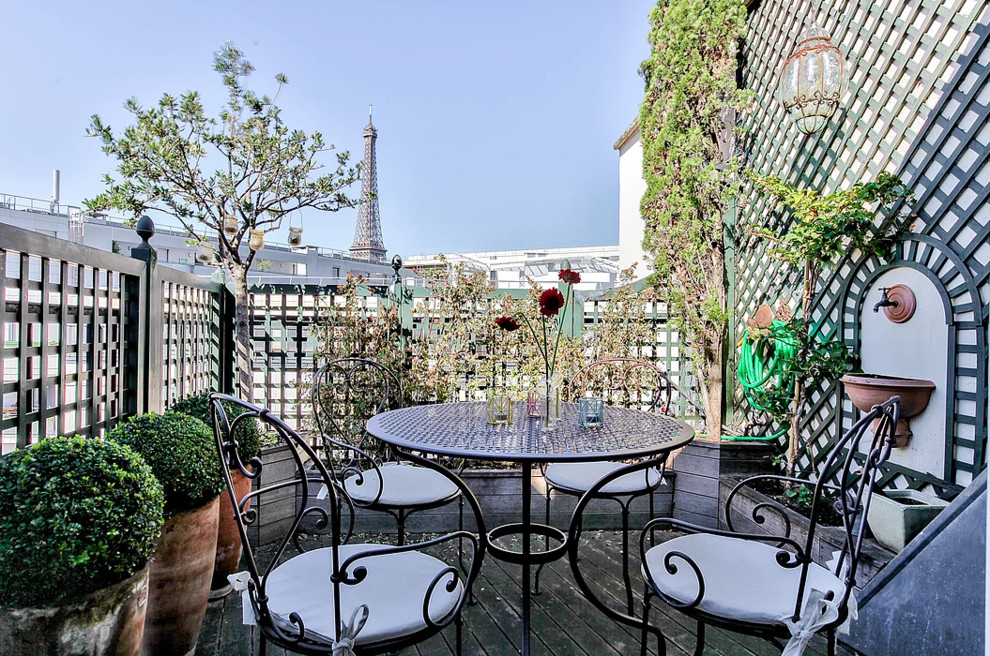 Photo of a small contemporary rooftop deck in Paris with a water feature and an awning.