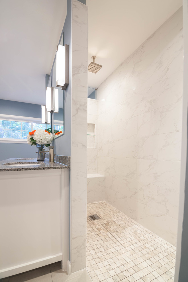Example of a large transitional master white tile and ceramic tile ceramic tile and beige floor drop-in bathtub design in Atlanta with shaker cabinets, white cabinets, a one-piece toilet, blue walls, an undermount sink and granite countertops