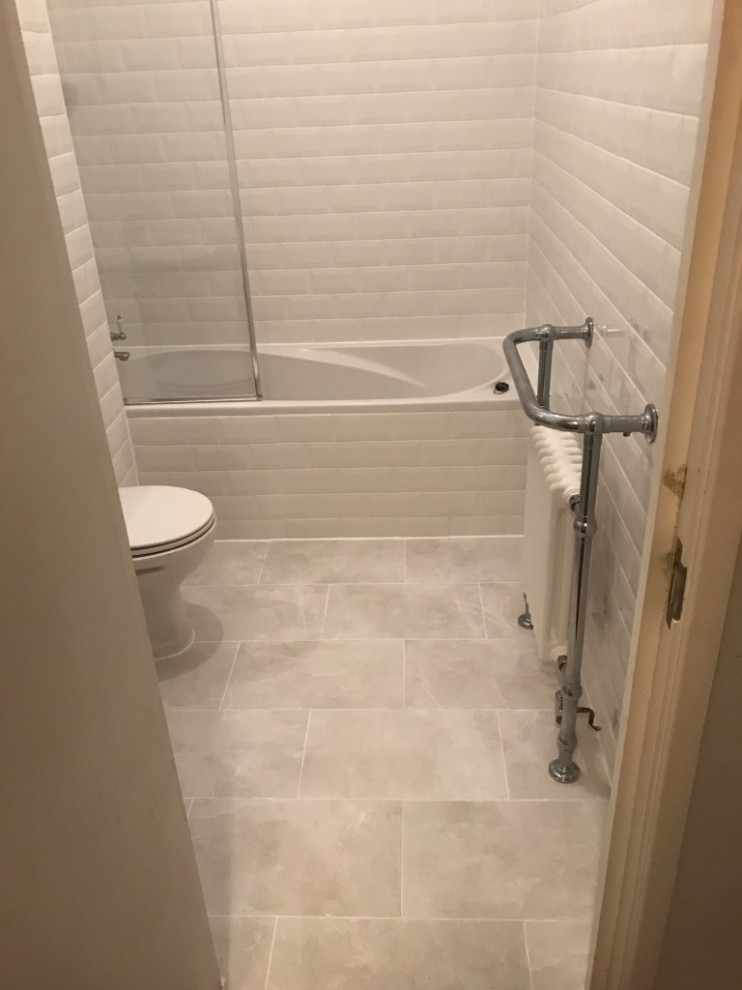 Photo of a mid-sized traditional kids bathroom in London with a freestanding tub, a curbless shower, a one-piece toilet, white tile, ceramic tile, white walls, ceramic floors, a pedestal sink, white floor, a hinged shower door and a single vanity.