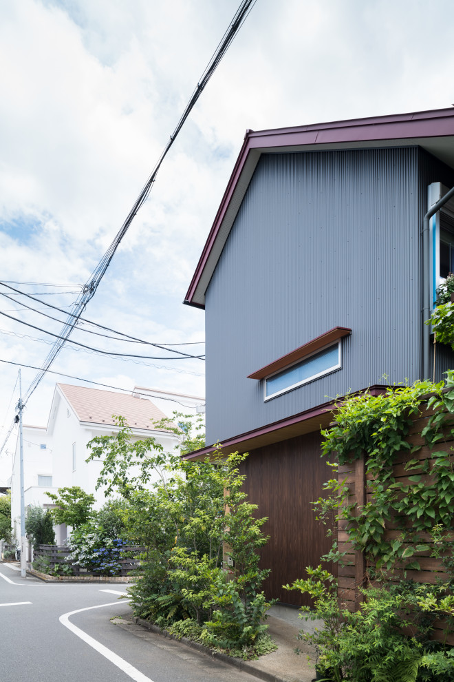 Design ideas for a small two-storey grey house exterior in Tokyo Suburbs with wood siding, a gable roof, a metal roof, a red roof and board and batten siding.