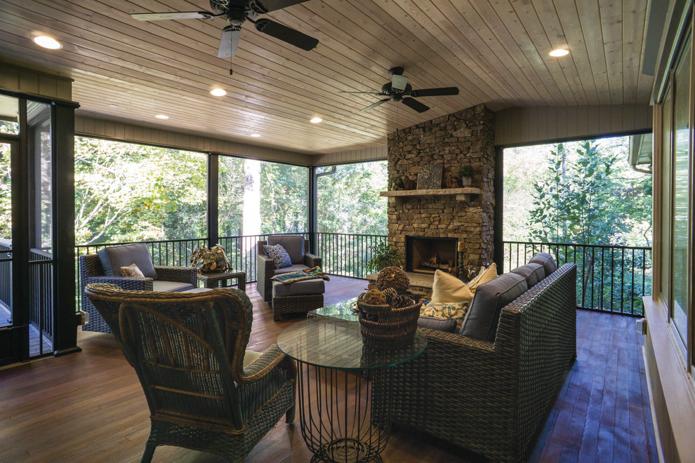 Photo of a large country sunroom in Atlanta with a standard fireplace, a stone fireplace surround, a standard ceiling, dark hardwood floors and brown floor.