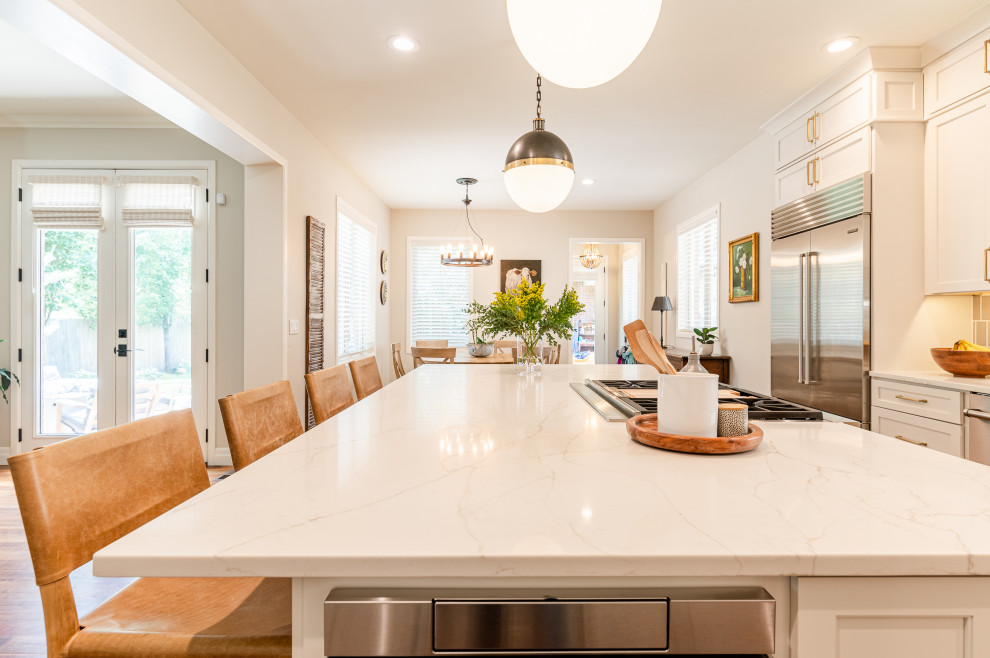 Inspiration for a large transitional l-shaped dark wood floor and brown floor open concept kitchen remodel in Denver with a farmhouse sink, shaker cabinets, beige cabinets, quartz countertops, beige backsplash, ceramic backsplash, stainless steel appliances, an island and white countertops