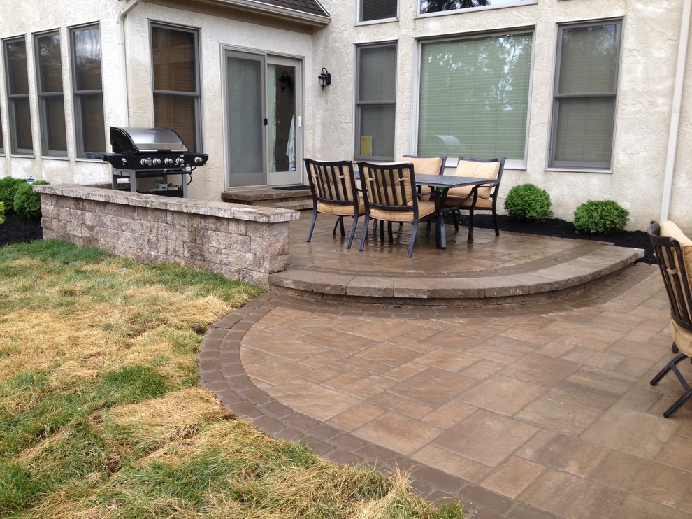 Inspiration for a mid-sized traditional backyard patio in Columbus with a fire feature and concrete pavers.