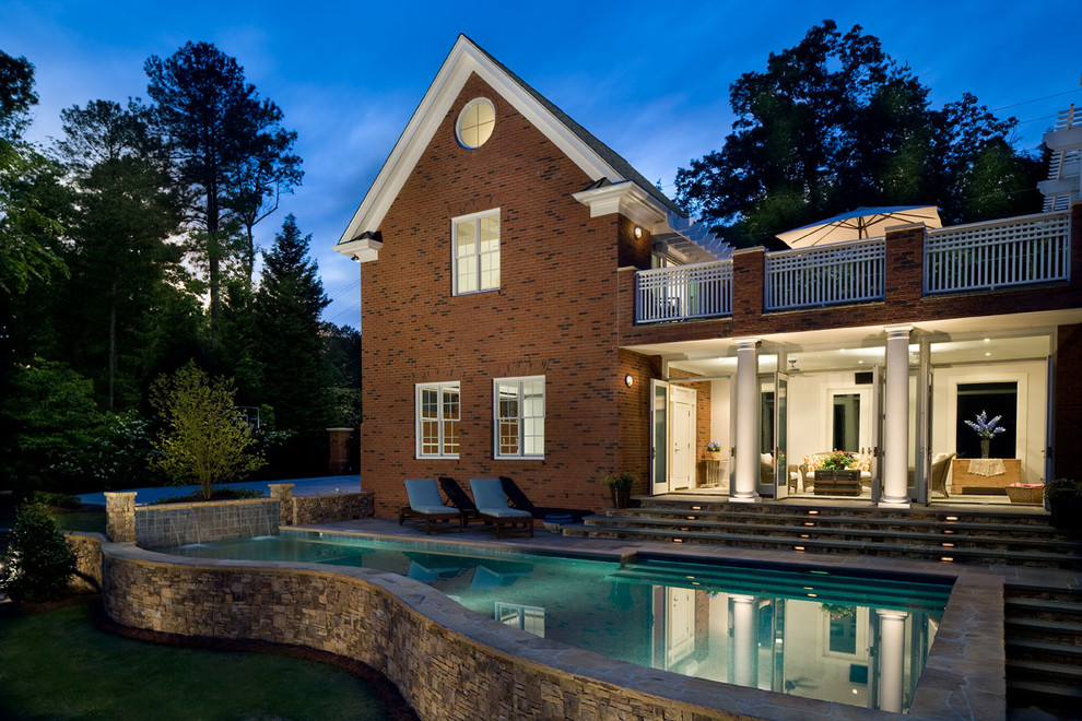 Expansive traditional backyard custom-shaped aboveground pool in Atlanta with a water feature and natural stone pavers.