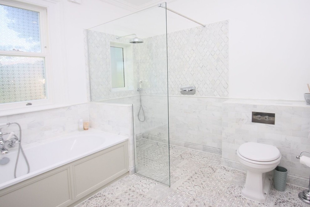 Design ideas for a large traditional master wet room bathroom in Other with shaker cabinets, beige cabinets, a corner tub, a wall-mount toilet, gray tile, porcelain tile, white walls, porcelain floors, a drop-in sink, marble benchtops, grey floor, an open shower and white benchtops.
