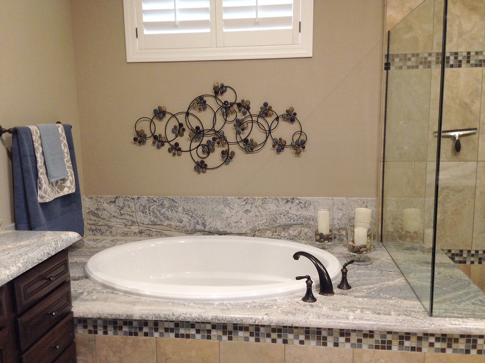 Mid-sized transitional master blue tile and mosaic tile ceramic tile drop-in bathtub photo in Phoenix with an undermount sink, raised-panel cabinets, dark wood cabinets, granite countertops, a two-piece toilet and beige walls