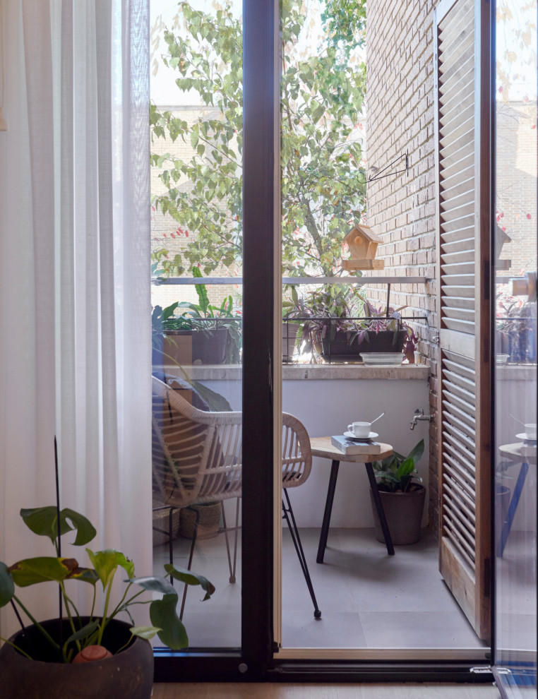 Imagen de terraza minimalista pequeña con jardín de macetas y barandilla de metal