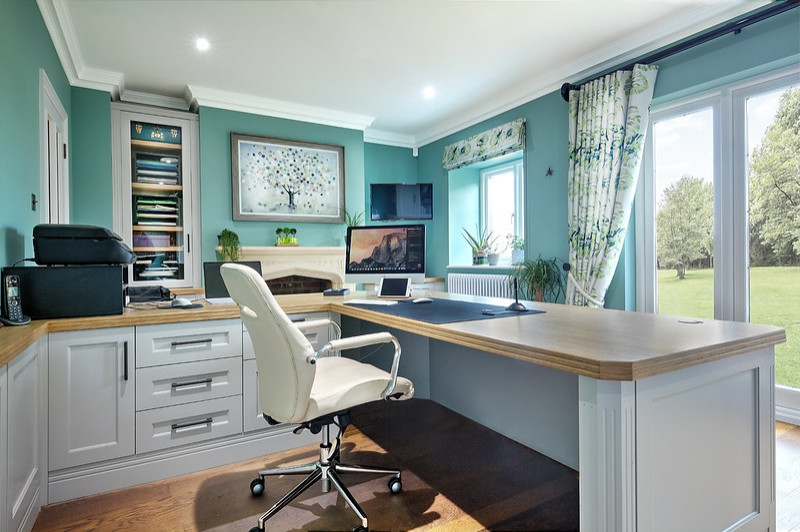 Design ideas for a transitional home office in Hampshire with green walls, dark hardwood floors and a standard fireplace.