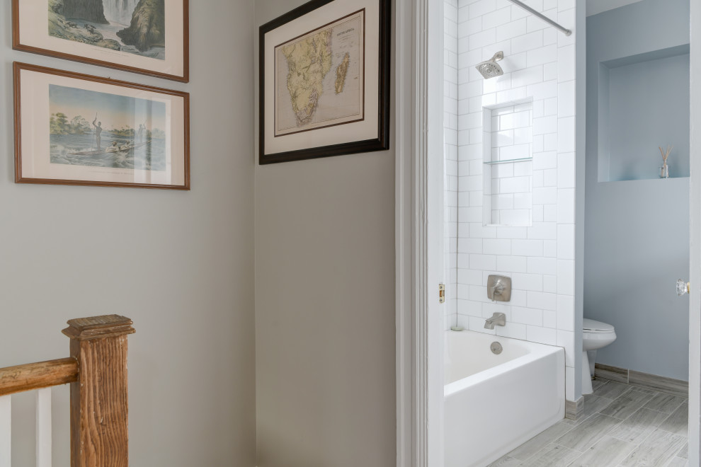 Alcove bathtub - transitional white tile and porcelain tile porcelain tile, gray floor and single-sink alcove bathtub idea with white cabinets, a two-piece toilet, blue walls, a pedestal sink and a freestanding vanity