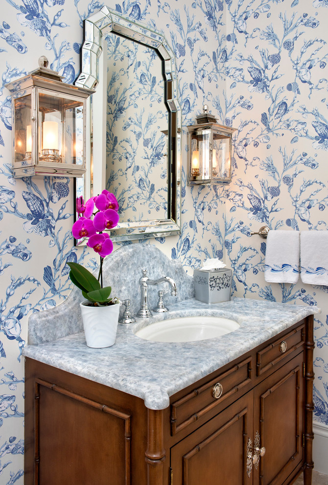Inspiration for a small tropical powder room remodel in Miami with furniture-like cabinets, medium tone wood cabinets, multicolored walls, an undermount sink, marble countertops and gray countertops