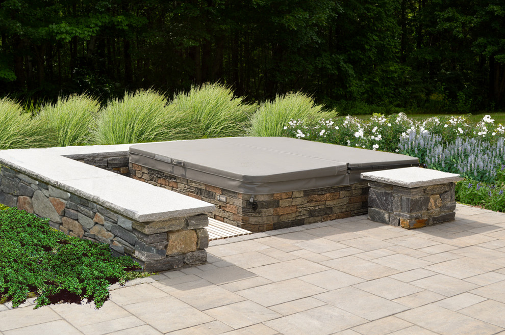 Inspiration for a mid-sized traditional backyard patio in Portland Maine with a water feature, natural stone pavers and no cover.