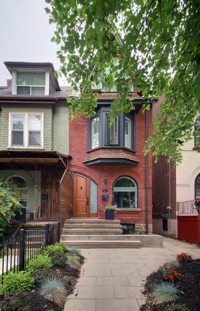 Photo of a small modern three-storey brick red exterior in Toronto.