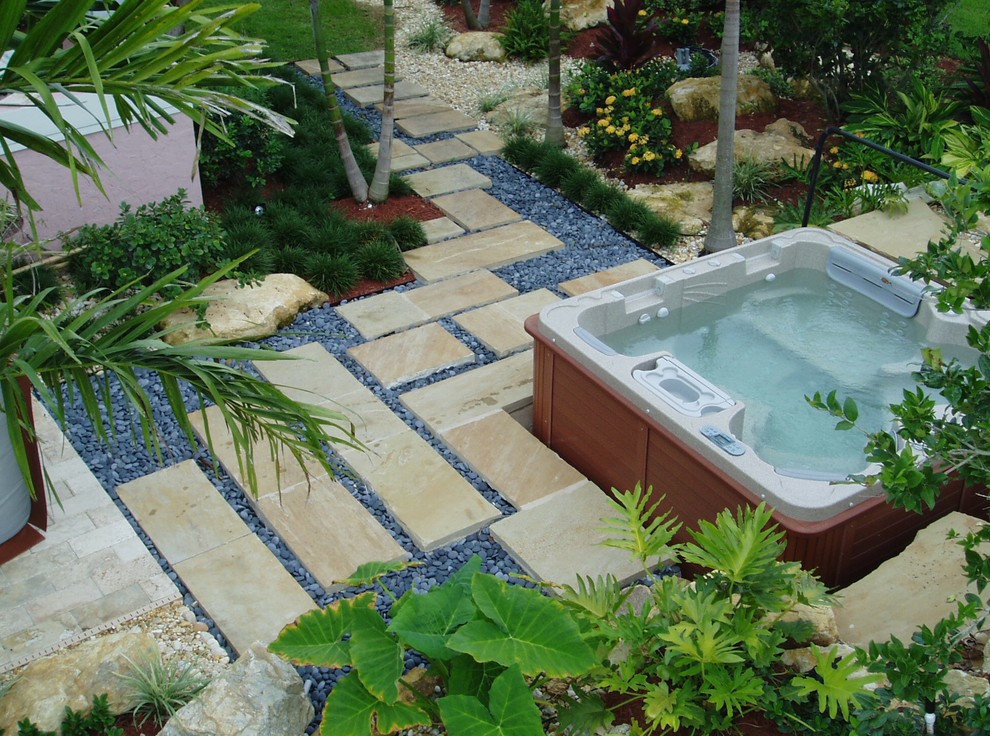 Photo of a tropical backyard full sun garden in Miami with a garden path and natural stone pavers.