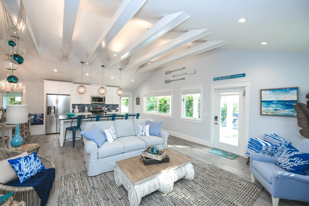 Inspiration for a beach style open concept living room in Tampa with blue walls, porcelain floors and grey floor.