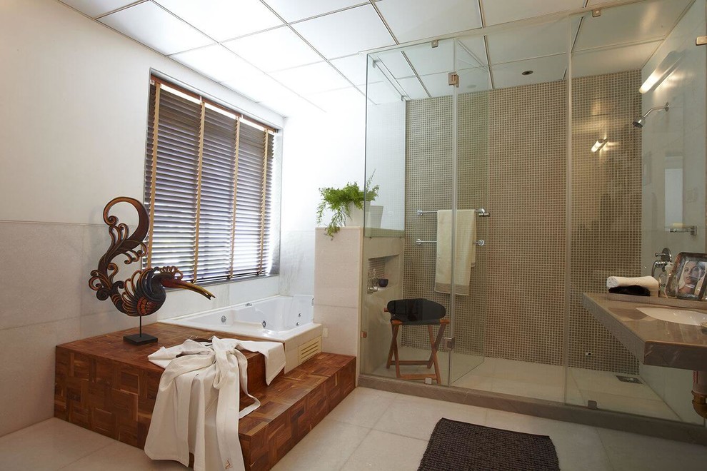 Photo of a large industrial master bathroom in Pune with glass-front cabinets, a hot tub, white tile and white walls.