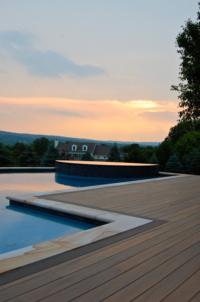 Design ideas for a mid-sized eclectic backyard custom-shaped pool in New York with decking.