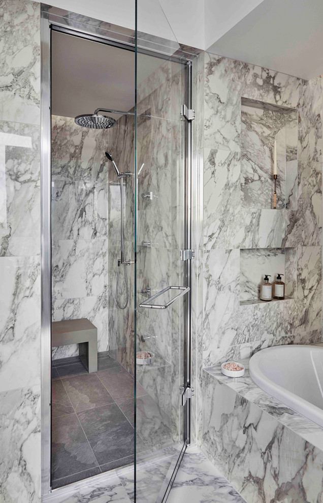 Mid-sized contemporary master bathroom in London with flat-panel cabinets, beige cabinets, an alcove tub, an alcove shower, multi-coloured tile, marble, multi-coloured walls, marble floors, soapstone benchtops, multi-coloured floor, a hinged shower door, grey benchtops, a shower seat, a double vanity and a floating vanity.