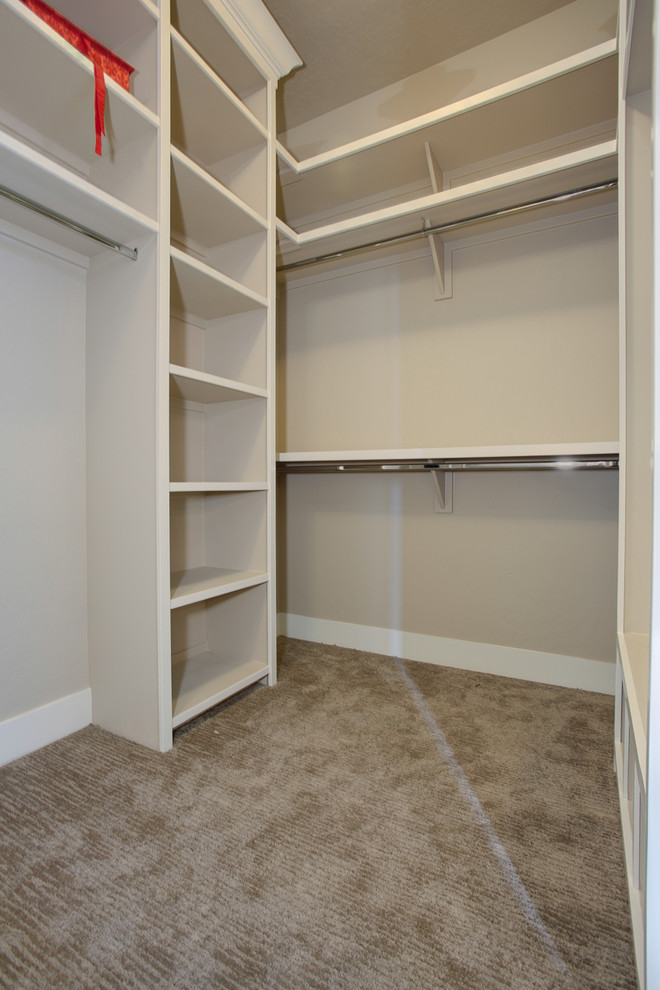 Mid-sized traditional gender-neutral walk-in wardrobe in Boise with open cabinets, grey cabinets and carpet.