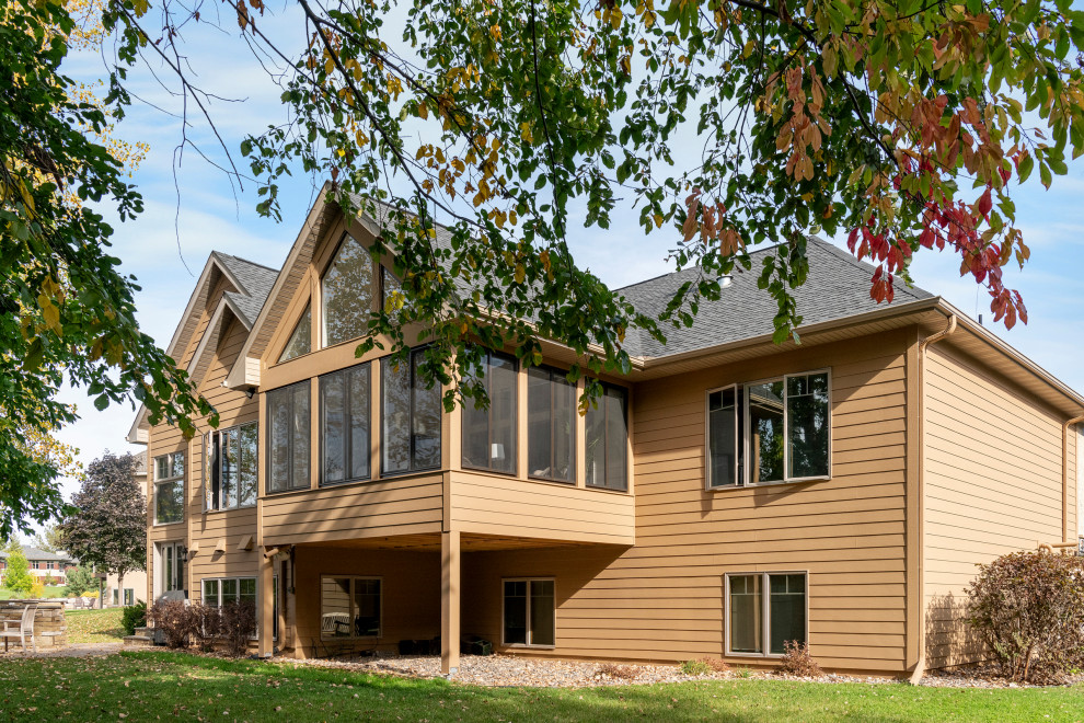 Ejemplo de fachada de casa beige y gris clásica grande de dos plantas con revestimiento de madera, tejado a dos aguas, tejado de teja de madera y teja