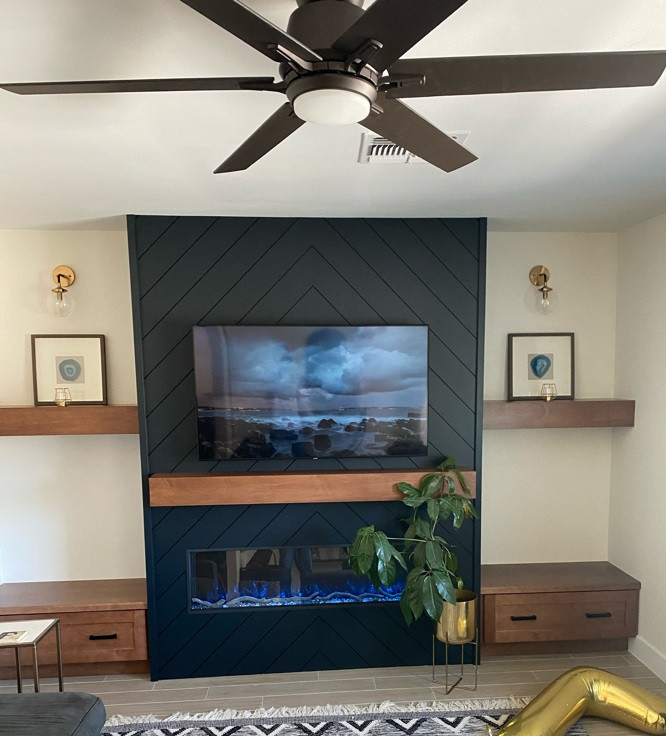 Mittelgroßes, Offenes Landhaus Wohnzimmer mit schwarzer Wandfarbe, Kaminumrandung aus Holzdielen, TV-Wand und Holzdielenwänden in Phoenix