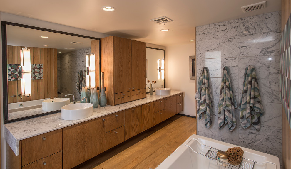 Transitional master bathroom in Phoenix with flat-panel cabinets, medium wood cabinets, a freestanding tub and a vessel sink.