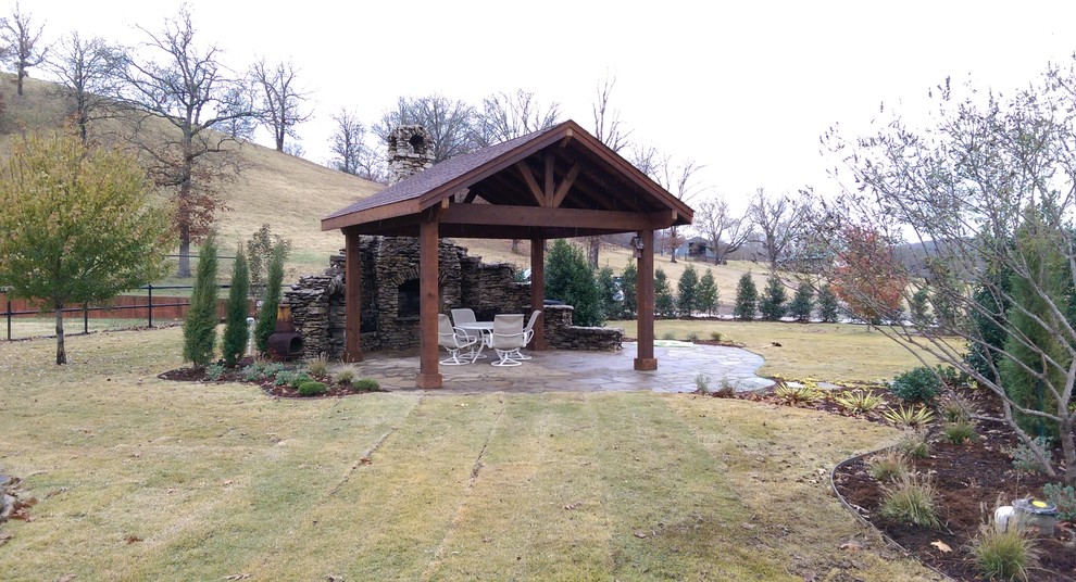 Inspiration for a rustic backyard stone and kidney-shaped lap pool fountain remodel