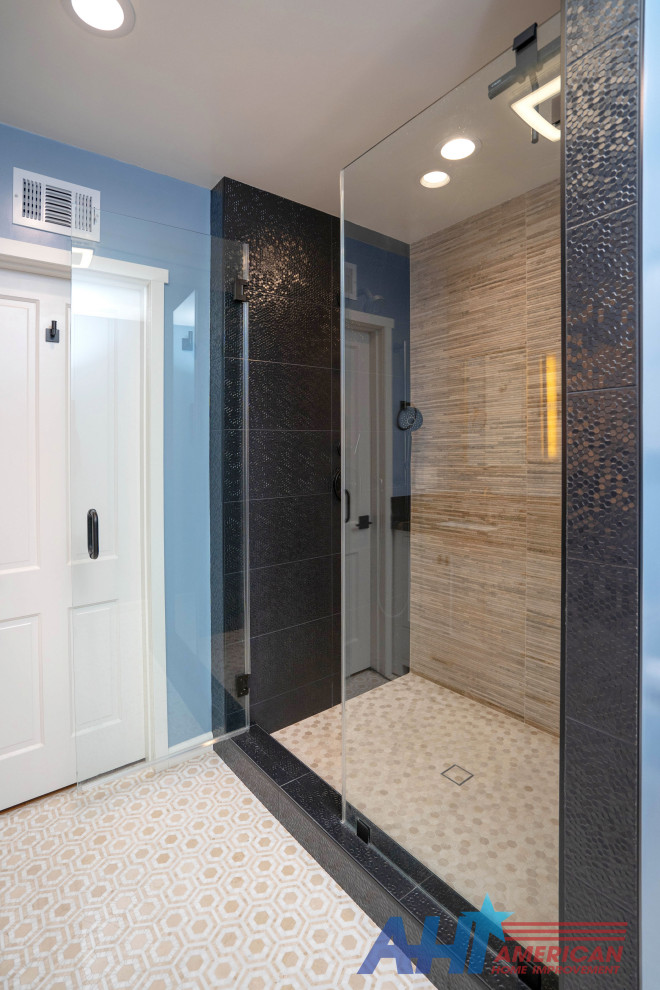 This is an example of a large modern ensuite bathroom in Los Angeles with raised-panel cabinets, white cabinets, a corner shower, a one-piece toilet, beige tiles, pebble tiles, blue walls, porcelain flooring, a built-in sink, marble worktops, white floors, a hinged door, black worktops, double sinks and a built in vanity unit.