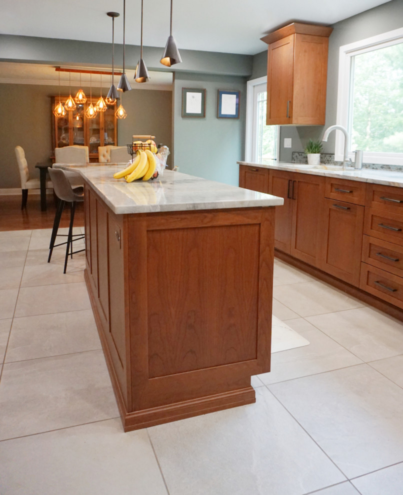 Eat-in kitchen - mid-sized transitional porcelain tile and gray floor eat-in kitchen idea with recessed-panel cabinets, medium tone wood cabinets, quartzite countertops, green backsplash, mosaic tile backsplash, stainless steel appliances and an island