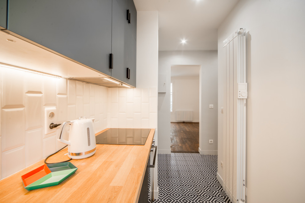 Foto di una piccola cucina con lavello sottopiano, top in legno, paraspruzzi con piastrelle in ceramica, elettrodomestici neri e pavimento in cementine