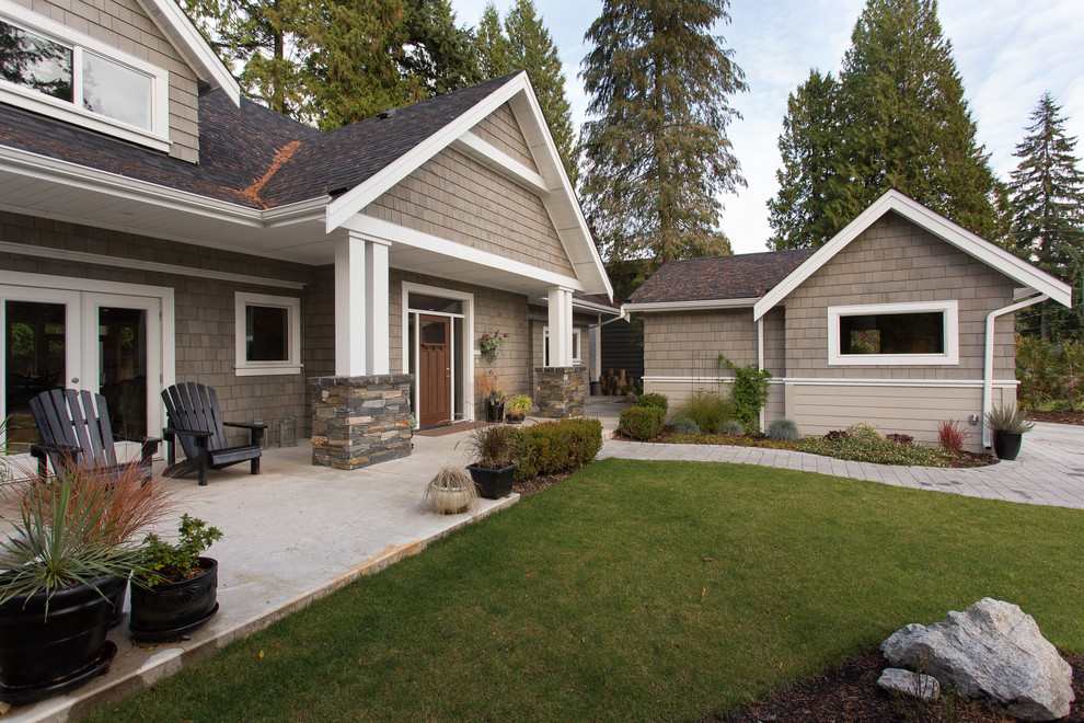 This is an example of a large transitional two-storey beige house exterior in Vancouver with wood siding, a gable roof and a shingle roof.