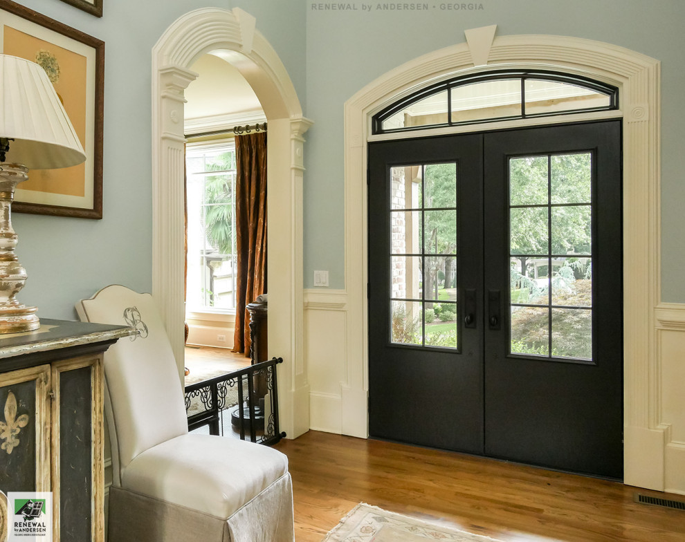 Inspiration for a medium sized foyer in Atlanta with blue walls, medium hardwood flooring, a double front door, a black front door, multi-coloured floors, a vaulted ceiling and wainscoting.