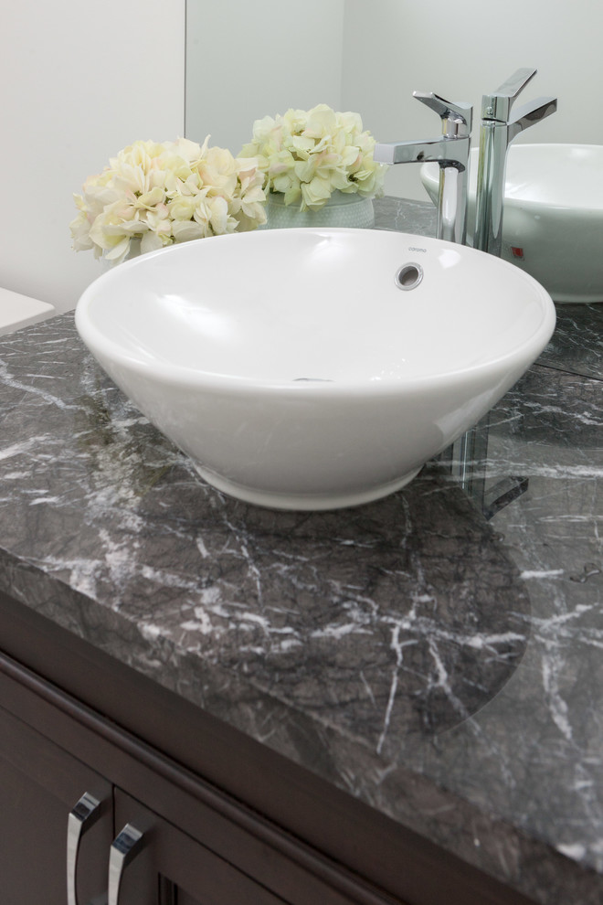 Design ideas for a mid-sized transitional powder room in Vancouver with a vessel sink, recessed-panel cabinets, dark wood cabinets, marble benchtops and grey walls.