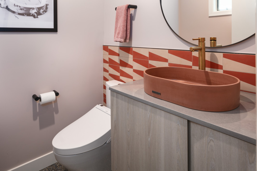 Inspiration pour un petit WC et toilettes minimaliste en bois clair avec un placard à porte plane, un bidet, un carrelage rouge, des carreaux de béton, un mur rose, un sol en terrazzo, une vasque, un plan de toilette en quartz modifié, un sol noir, un plan de toilette gris et meuble-lavabo suspendu.