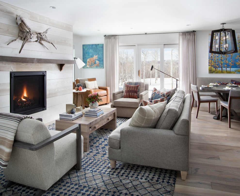 Inspiration for a transitional open concept living room in Denver with white walls, light hardwood floors, grey floor and a standard fireplace.