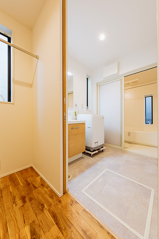 Design ideas for a mid-sized modern single-wall utility room in Tokyo Suburbs with an integrated sink, flat-panel cabinets, brown cabinets, solid surface benchtops, white walls, porcelain floors and beige floor.