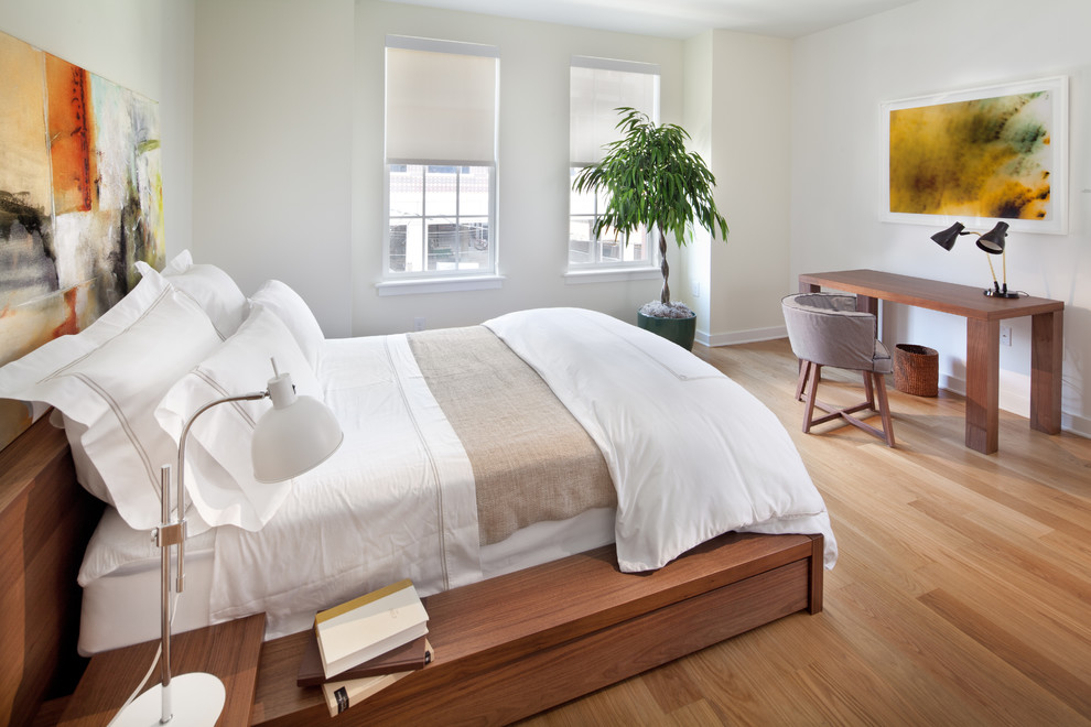 Photo of a contemporary bedroom in DC Metro with white walls and light hardwood floors.