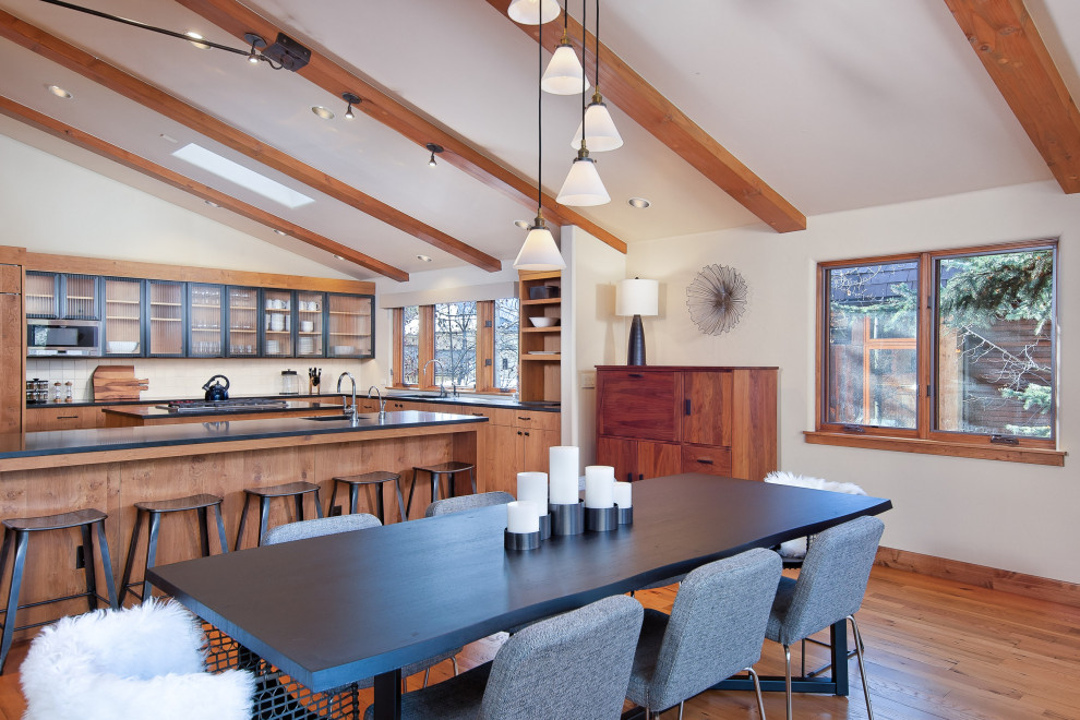 Cette image montre une salle à manger ouverte sur le salon traditionnelle de taille moyenne avec un mur blanc, un sol en bois brun, un sol marron et un plafond voûté.