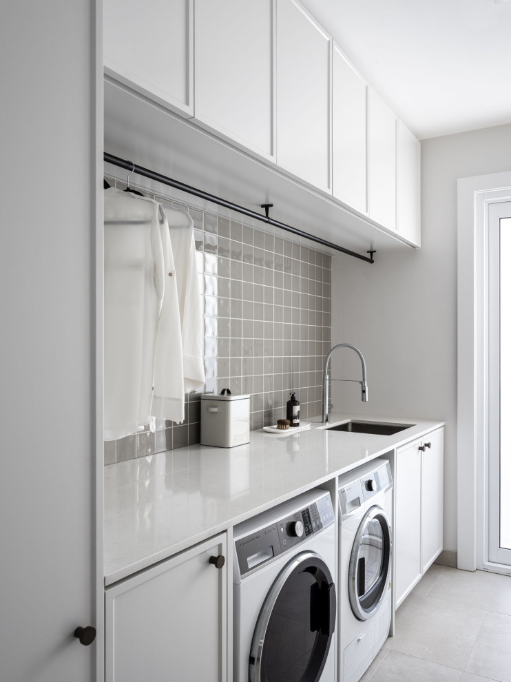 Design ideas for a small modern single-wall utility room in Perth with a drop-in sink, recessed-panel cabinets, light wood cabinets, quartz benchtops, ceramic splashback, a side-by-side washer and dryer and white benchtop.