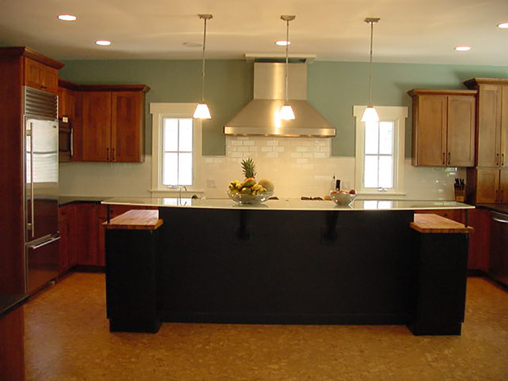 This is an example of a large arts and crafts u-shaped eat-in kitchen in Chicago with glass benchtops, white splashback, subway tile splashback, cork floors, stainless steel appliances, an undermount sink, shaker cabinets, medium wood cabinets and with island.