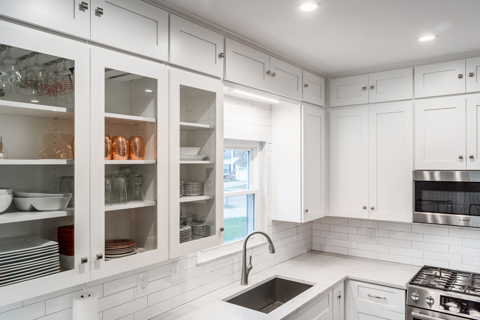Example of a mid-sized transitional l-shaped eat-in kitchen design in Columbus with shaker cabinets, quartz countertops, white backsplash, subway tile backsplash and an island