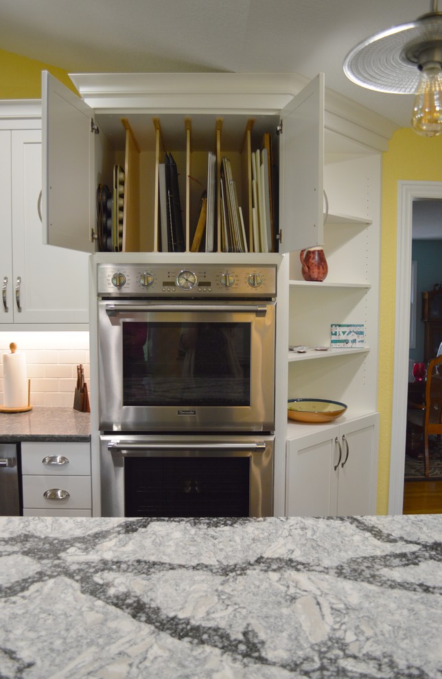 Large dark wood floor kitchen photo with shaker cabinets, white cabinets, quartzite countertops, white backsplash, subway tile backsplash, stainless steel appliances and an island