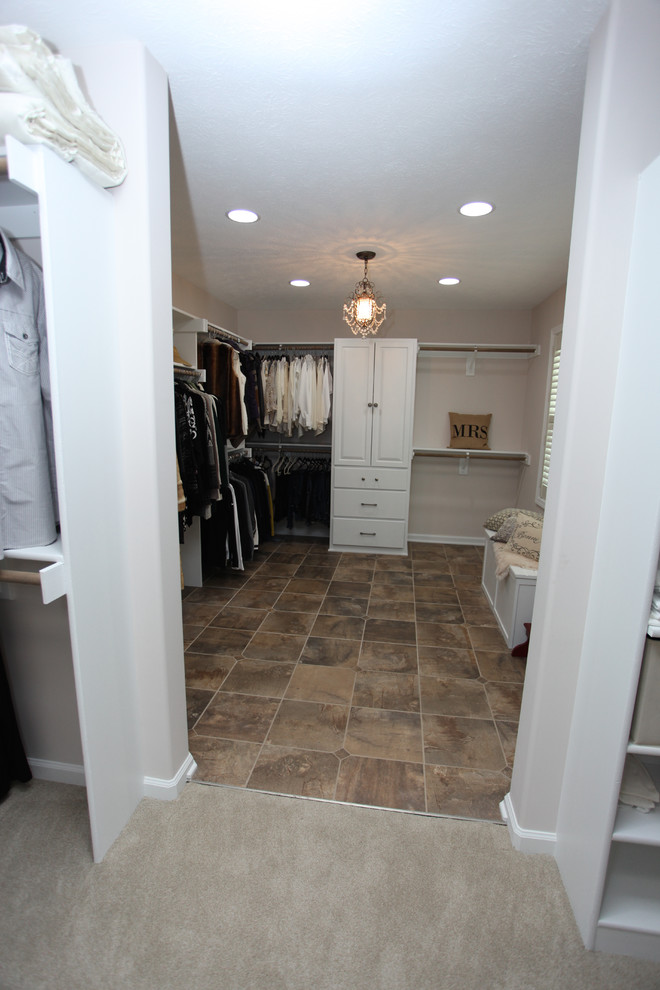 Inspiration for a mid-sized traditional gender-neutral walk-in wardrobe in Indianapolis with raised-panel cabinets, white cabinets, slate floors and brown floor.