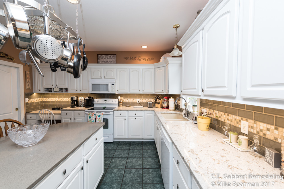Inspiration for a mid-sized transitional l-shaped kitchen remodel in Chicago with a double-bowl sink, beaded inset cabinets, white cabinets, quartz countertops, beige backsplash, subway tile backsplash, stainless steel appliances and an island